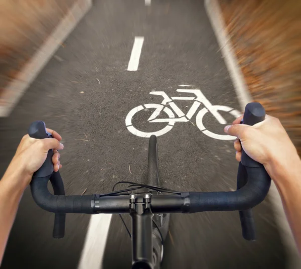 一名骑自行车的人正在骑一辆新的公路自行车穿过自行车道 — 图库照片
