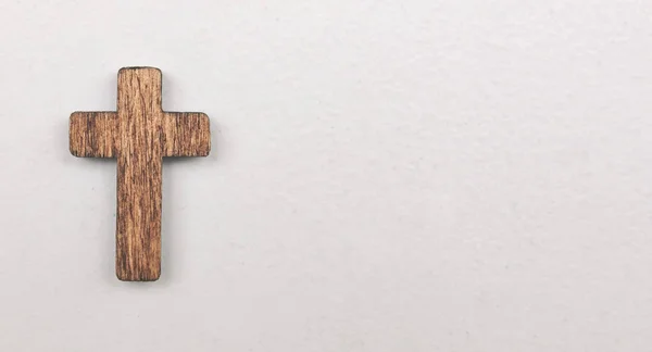 A little wooden cross on the white background