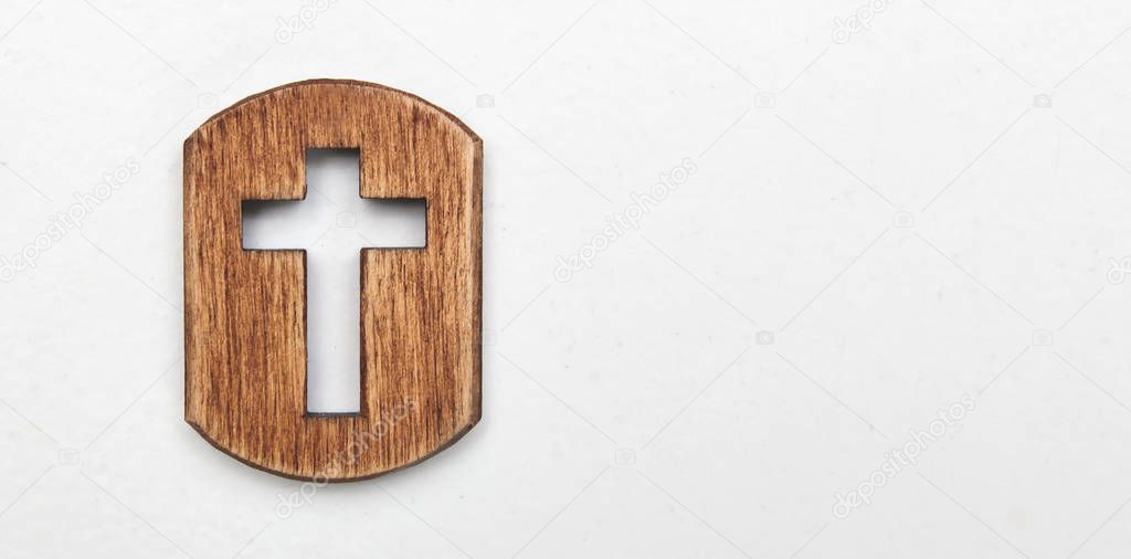 A little wooden cross on the white background