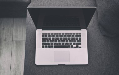 Yeni gri kanepede modern dizüstü bilgisayar