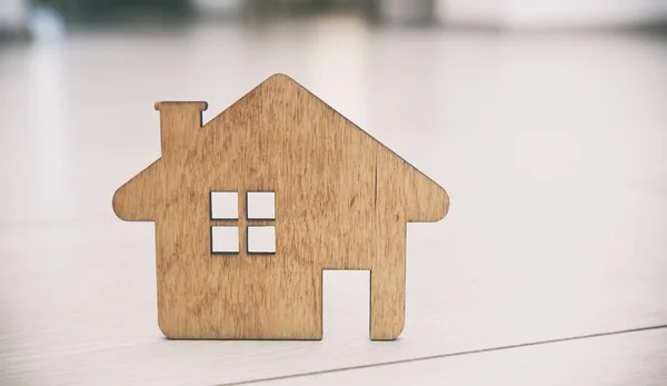 Een klein plat houten huis ligt op de parketvloer — Stockfoto