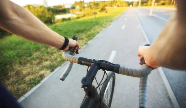 The young guy is riding the bike through the city — Stock Photo, Image