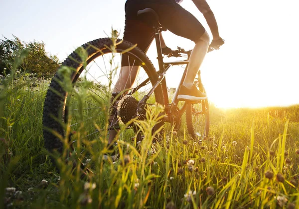 The young man is riding the bike through the path with a lot of — Stock Photo, Image