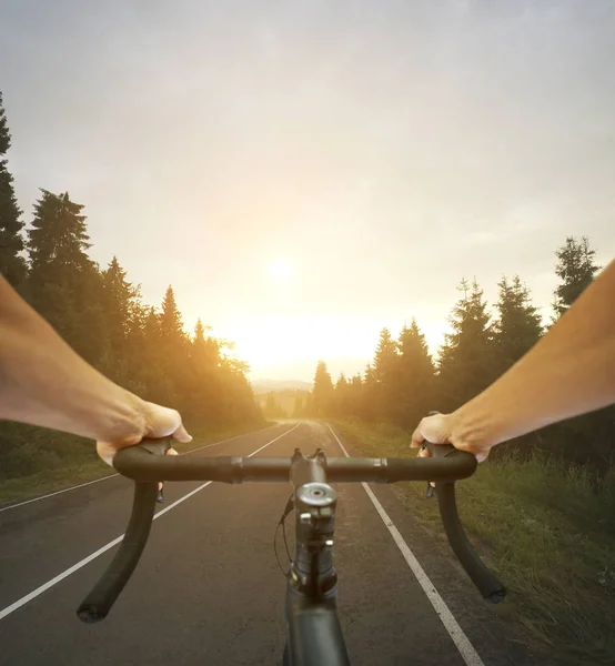 The cyclist is riding through the the asphalt road — Stock Photo, Image