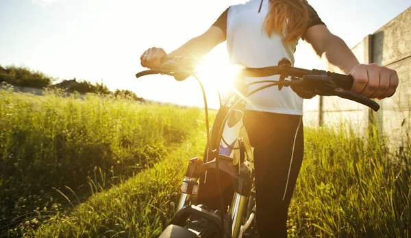 The young woman is riding the mountain bike through the path wit — Stock Photo, Image