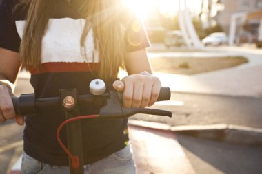 Genç kadın ev ile elektrikli scooter biniyor