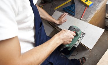 Adam yapbozla tahta kesiyor.