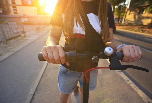 年轻女子骑着电动滑板车通过ev — 图库照片