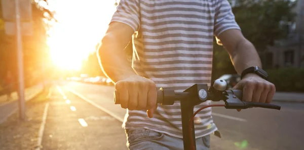 De jonge man rijdt op de elektrische scooter door de zelfs — Stockfoto