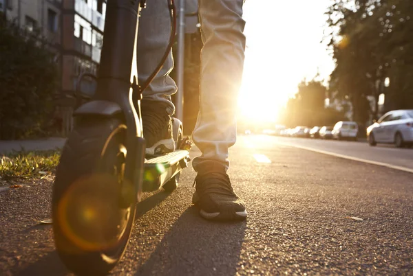 De jonge man rijdt op de elektrische scooter door de zelfs — Stockfoto