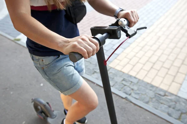 Młoda kobieta jedzie na skuterze elektrycznym przez EV — Zdjęcie stockowe