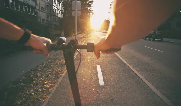 De jonge man rijdt op de elektrische scooter door de zelfs — Stockfoto