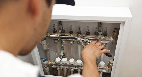 O homem está instalando o sistema de aquecimento na casa e checkin — Fotografia de Stock