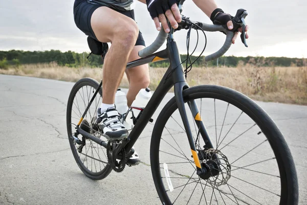 O ciclista está treinando em sua bicicleta de estrada fora da cidade por asp — Fotografia de Stock