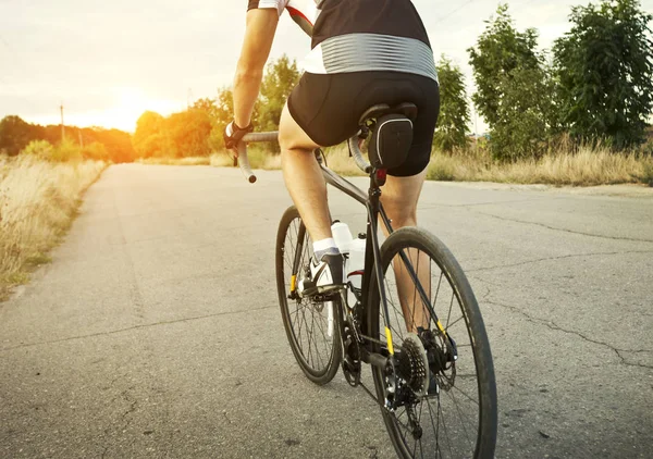 Il ciclista si allena sulla sua bici da strada fuori città a portata di mano — Foto Stock