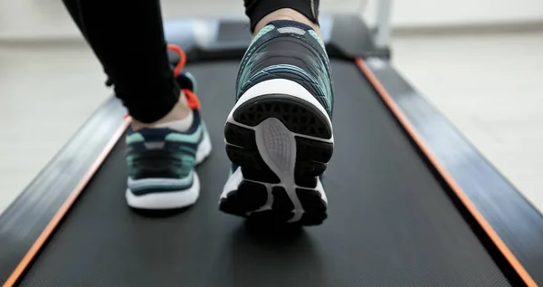 Frauenbeine in neuen Turnschuhen auf dem Laufband — Stockfoto