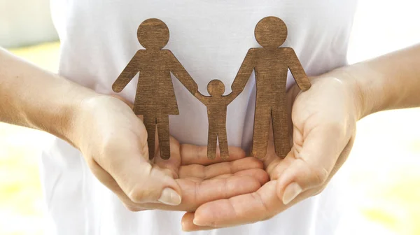 Wooden statuettes of mother, father and their child  in the woma — Stock Photo, Image