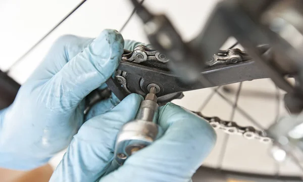 El mecánico está arreglando la bicicleta de carretera en su taller — Foto de Stock