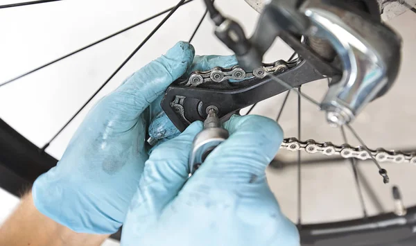 El mecánico está arreglando la bicicleta de carretera en su taller —  Fotos de Stock