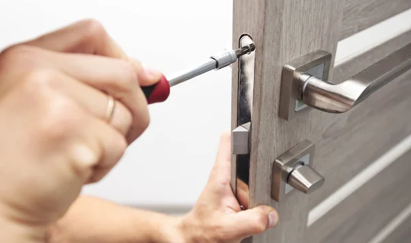 Mannen är att installera den del av trä dörren av screwdr — Stockfoto