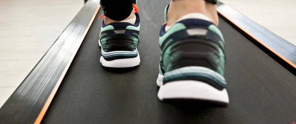 Frauenbeine in neuen Turnschuhen auf dem Laufband — Stockfoto