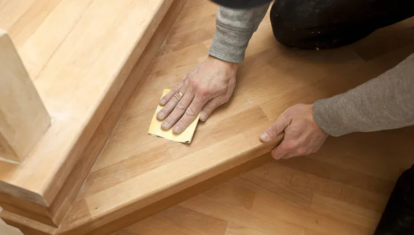 Wood grinding process by sandpaper. The young carpenter works wi — Stock Photo, Image