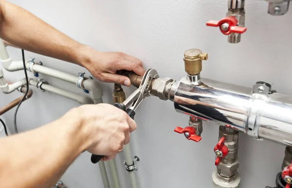 O homem está instalando o sistema de aquecimento na casa e checkin — Fotografia de Stock