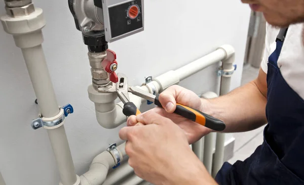 The man is installing the heater system in the house and checkin — Stock Photo, Image