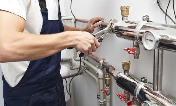 The man is installing the heater system in the house and checkin — Stock Photo, Image