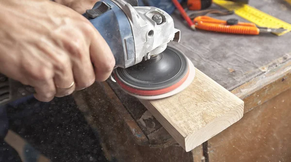 L'uomo sta macinando il pannello di legno — Foto Stock