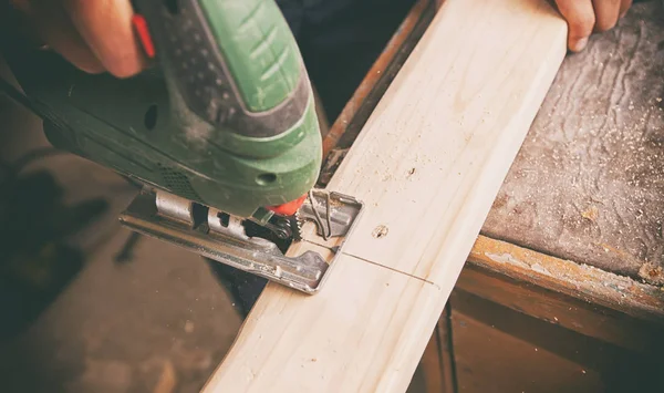 L'uomo sta tagliando la tavola di legno con un puzzle. — Foto Stock