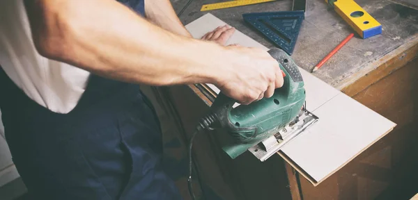 The man is cutting the laminate  by jigsaw — Stock Photo, Image