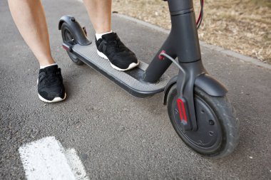 Genç kadın ev ile elektrikli scooter biniyor