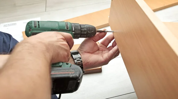 El hombre está montando muebles de madera en casa — Foto de Stock