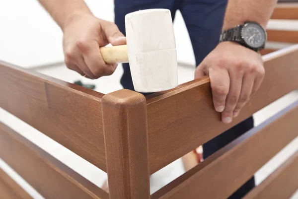 El hombre está montando muebles de madera en casa — Foto de Stock