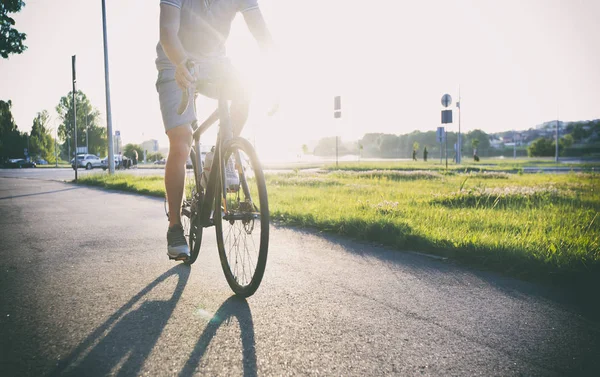 Le jeune homme fait du vélo à travers la ville — Photo