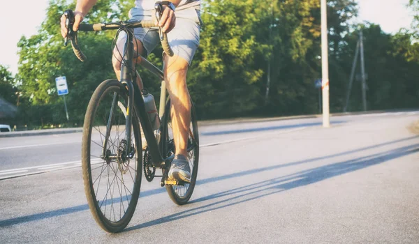 那个年轻人正在骑自行车穿过城市 — 图库照片