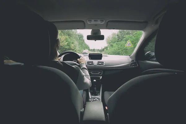 El joven que conduce el coche moderno en la carretera de asfalto —  Fotos de Stock