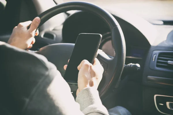 Jovem Está Olhando Seu Telefone Enquanto Dirige Carro — Fotografia de Stock