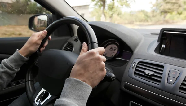 The young man driving the modern car on asphalt road — Stock Photo, Image