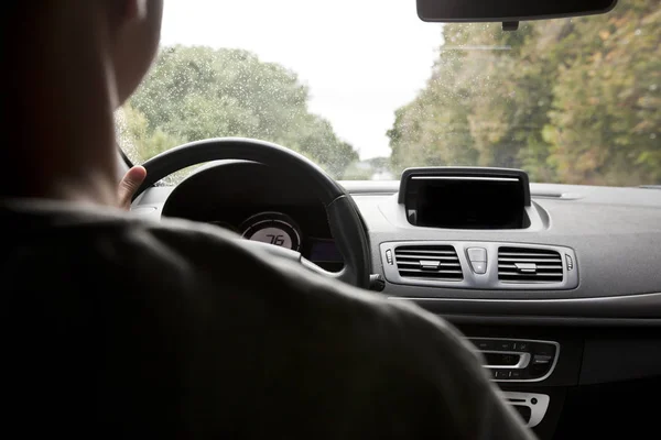 The young man driving the modern car on asphalt road — Stock Photo, Image