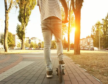 Genç adam elektrikli scooter üzerinde bile biniyor