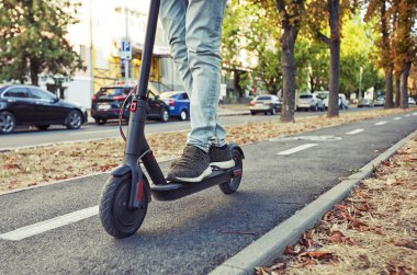 Genç adam elektrikli scooter üzerinde bile biniyor