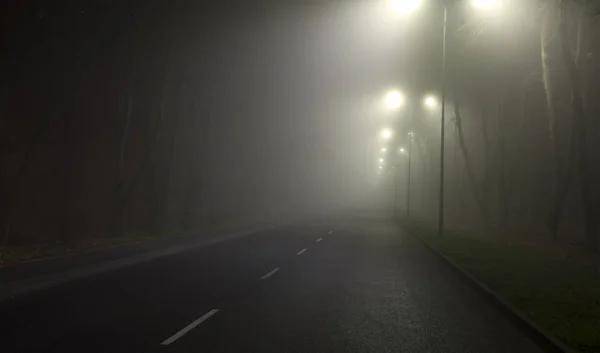 Gęsta mgła nad asfaltową drogą w nocy w mieście — Zdjęcie stockowe