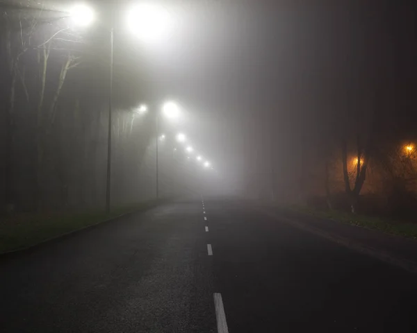 夜深的浓雾笼罩着城市的沥青路面 — 图库照片