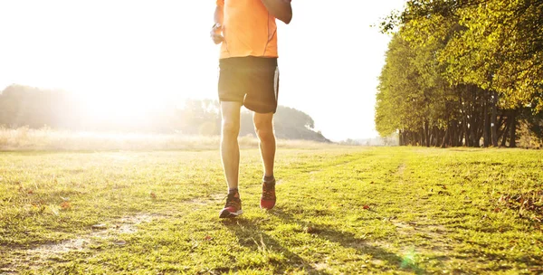 Ένας νεαρός άνθρωπος κάνει τζόκινγκ cross-country μέσα από το μονοπάτι στο — Φωτογραφία Αρχείου