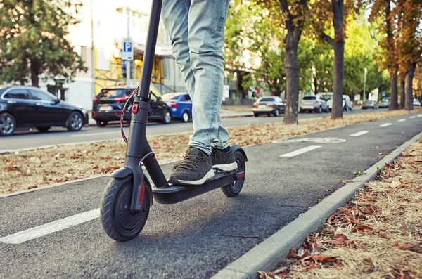 Genç adam elektrikli scooter üzerinde bile biniyor