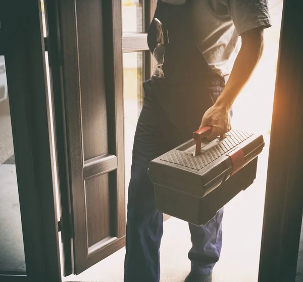 The repairer is coming in the house with toolbox in his hand — Stock Photo, Image