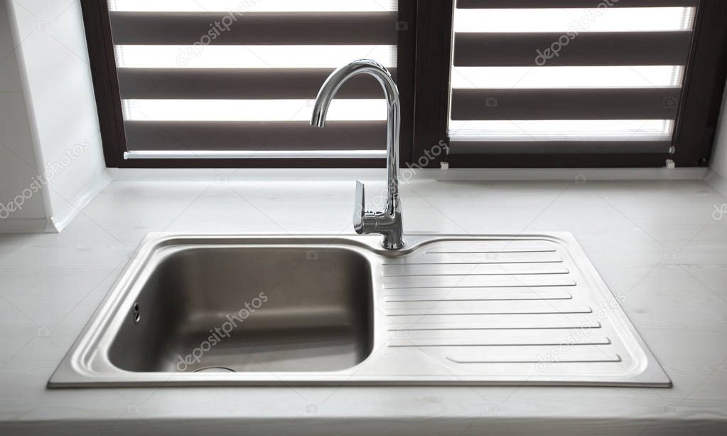 Metal faucet in the modern gray kitchen