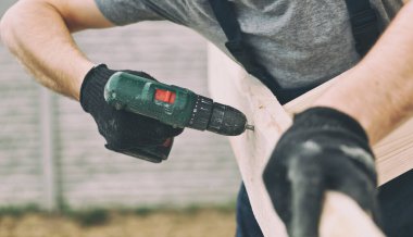 Çatı işçisi çatıdaki tahtayı vidaladı.